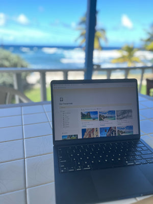 Laptop on a tiled surface with a scenic background