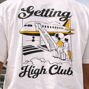 White t-shirt with airplane graphic and 'Getting High Club' text on a person wearing it.