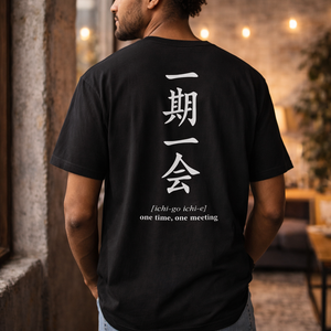 Man wearing a black t-shirt with white text and Japanese symbols, standing indoors. Ichi-go Ichi-e.