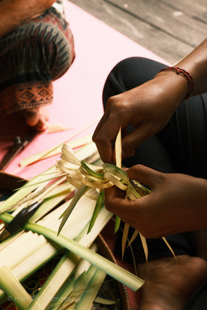 Person crafting with green leaves on a pink mat