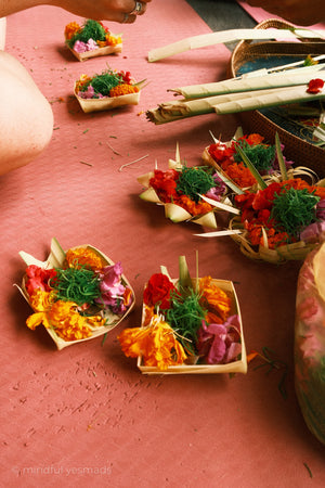 Decorative flower arrangements in small baskets on a pink surface