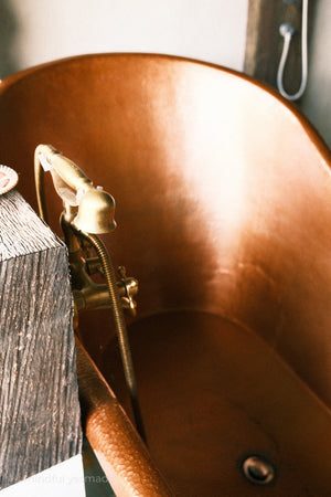 Close-up of a telephone faucet in copper bath tub.