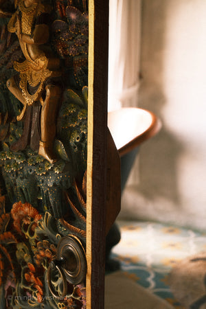 Decorative wooden panel with intricate carvings in a softly lit room.