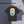 Black t-shirt with a colorful graphic of Mount Fuji on a hanger against a gray background