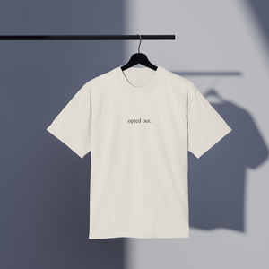 White t-shirt with 'opted out.' text on a hanger against a gray background
