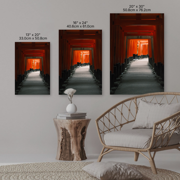 Four wall art prints of a hallway with orange doors, each with its dimensions, displayed on a wall above a sofa and side table.
