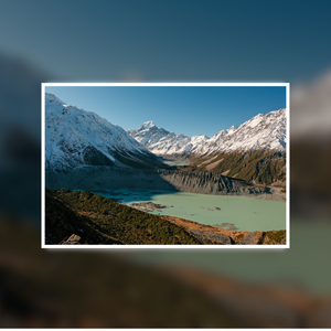 Scenic view of a lake surrounded by snow-capped mountains under a clear blue sky. Features Mount Cook / Aoraki and nearby lakes in New Zealand.