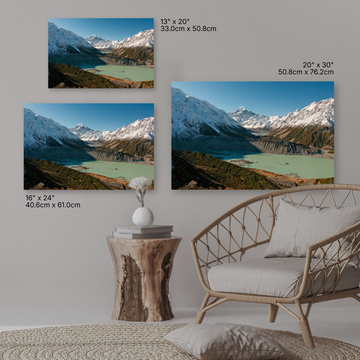 Three mountain landscape wall art prints displayed on a wall above a sofa.
