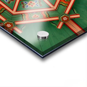 Decorative ceiling with geometric patterns and a small metallic object on a white background. featuring Dancheong geometric patterns in Seoul, South Korea.