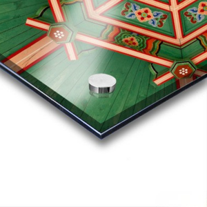 Decorative ceiling with geometric patterns and a small round object on a white background. featuring Dancheong geometric patterns in Seoul, South Korea.