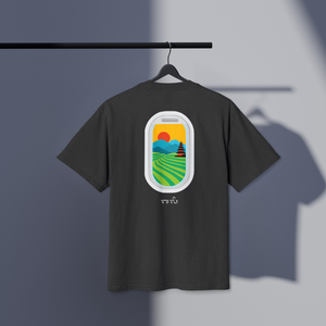 Black t-shirt with a colorful Bali rice fields and mountains and temple graphic on a hanger against a gray background