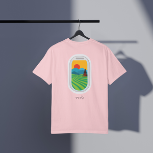 Pink t-shirt with a scenic Bali rice fields, mountains, and temple graphic on a hanger against a dark background