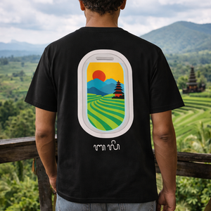 Person wearing a black t-shirt with a colorful Bali rice fields graphic design of a temple and landscape.